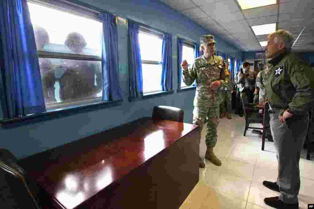 척 헤이글 미국 국방장관(오른쪽)이 30일 판문점을 방문해 군사정전위원회 회의장에서 미군 관계자의 설명을 듣고 있다. 창문 너머에선 북한 병사들(왼쪽)이 헤이글 장관의 모습을 카메라에 담고 있다.