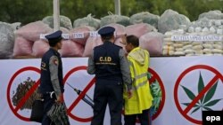 Myanmar police officers examine a pile of drugs during a 'Destruction Ceremony of Seized Narcotic Drugs' held to mark the International Day against Drug Abuse in Yangon, Myanmar, 26 June 2016. (EPA/NYEIN CHAN NAING)