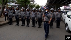 FILE - Police officers stand in position to block activists during a rally in Yangon, Myanmar, May 12, 2018.