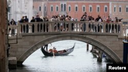 Turis menikmati suasana di Venesia, Italia, 16 Mei 2021, setelah negara tersebut menghapus kebijakan karantina. (REUTERS/Manuel Silvestri)