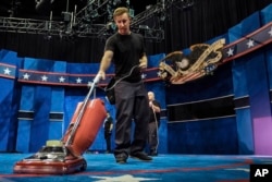 A stagehand vacuums the carpet as preparations continue Oct. 17, 2016, at the University of Nevada, Las Vegas for the final debate Wednesday between Democratic presidential nominee Hillary Clinton and Republican presidential nominee Donald Trump.