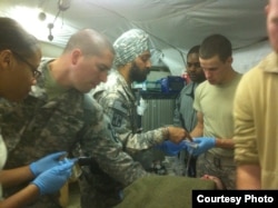 Major Kamal Kalsi works on a patient at Camp Dwyer in Helmand province, Afghanistan, 2011. (Photo courtesy of Major Kalsi)