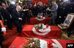 FILE - Tunisian President Beji Caid Essebsi decorates members from the presidential guards who were killed in a bomb blast on a bus in central Tunis the previous day during a ceremony at Carthage Palace, Tunis, Nov. 25, 2015.