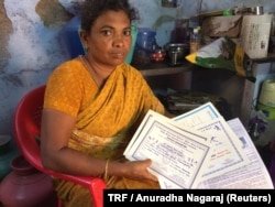 Maragatham Poomari holds her daughter’s school certificates in their home in Ayanapuram village in Tamil Nadu, India, July 27, 2017.