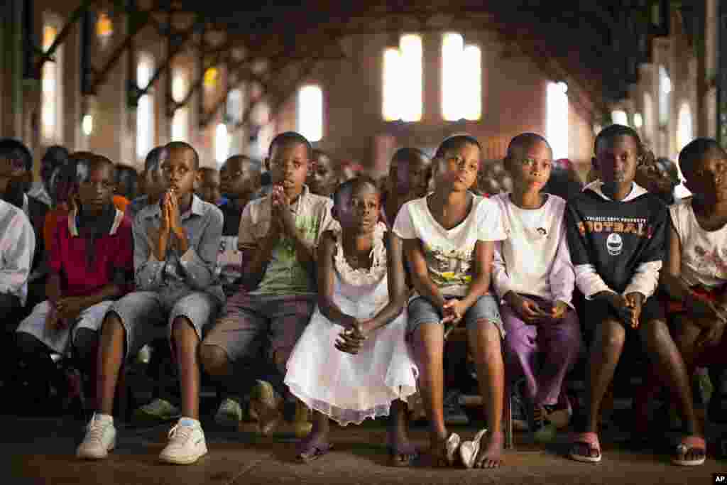 Watoto wa Rwanda wasikiliza na kuomba dua wakati wa ibada ya Jumapili katika kanisa la Saint-Famille Catholic, mahala ambapo watu wengi waliuliwa wakati ya mauwaji ya 1994 katika mji mkuu wa Kigali, April 6, 2014.