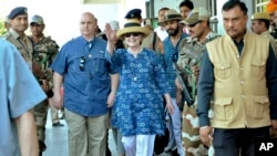 Former U.S. Secretary of State Hillary Clinton, center, waves as she comes out of the Jodhpur airport upoon her arrival in Jodhpur, Rajasthan state, India, March 13, 2018.