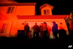 Residents and their friends watch neighboring homes burn as the Hillside fire tears through San Bernardino, Calif., on Thursday, Oct. 31, 2019.