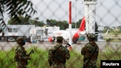 Soldados montan guardia en la escena del crimen luego de que dos explosiones en el aeropuerto internacional Camilo Daza mataran a varias personas, en Cúcuta, Colombia el 14 de diciembre de 2021. Fotografía tomada a través de una valla.