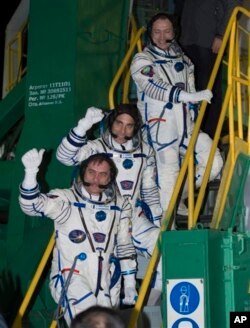 Tiga astronot yang berangkat ke Stasiun Antariksa Internasional (ISS) Alexander Misurkin (paling atas), Chris Cassidy (dari NASA, tengah), dan Pavel Vinogradov (bawah) melambaikan tangan sebelum memasuki kapsul Soyuz di kosmodrom Baikonur, Kazakhstan (29/3).