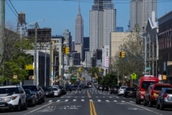 Sparse traffic moves along 47th Avenue, Wednesday, May 13, 2020, in the Queens borough of New York.
