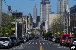 Sparse traffic moves along 47th Avenue, Wednesday, May 13, 2020, in the Queens borough of New York.