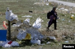 Seorang migran melewati selimut pertolongan pertama di perbatasan Austria-Hungaria, berjalan menuju Nickelsdorf, Austria, 20 September 2015. (Foto: Reuters)