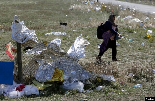 Seorang migran melewati selimut pertolongan pertama di perbatasan Austria-Hungaria, berjalan menuju Nickelsdorf, Austria, 20 September 2015. (Foto: Reuters)