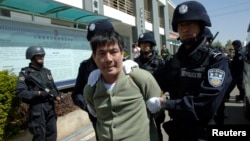 Tử tù Naw Kham trên đường tới phòng hành quyết ở Côn Minh, tỉnh Vân Nam, 1/3/2013. REUTERS/China Daily 