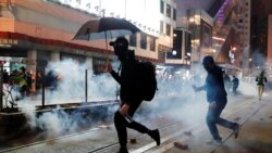 Manifestantes prodemocracia en Hong Kong huyen de gases lacrimógenos lanzados por la policía durante una marcha el Día de Año Nuevo el 1 de enero de 2020.