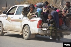 Families pile into soldiers' pickup trucks as they flee western Mosul, Feb. 26, 2017. (Mahmood Alsalih/VOA)