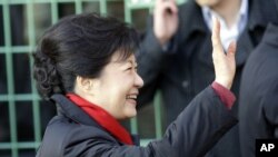 保守派執政黨新國家黨的候選人朴槿惠星期三在首爾的一個投票站向支持者揮手致意