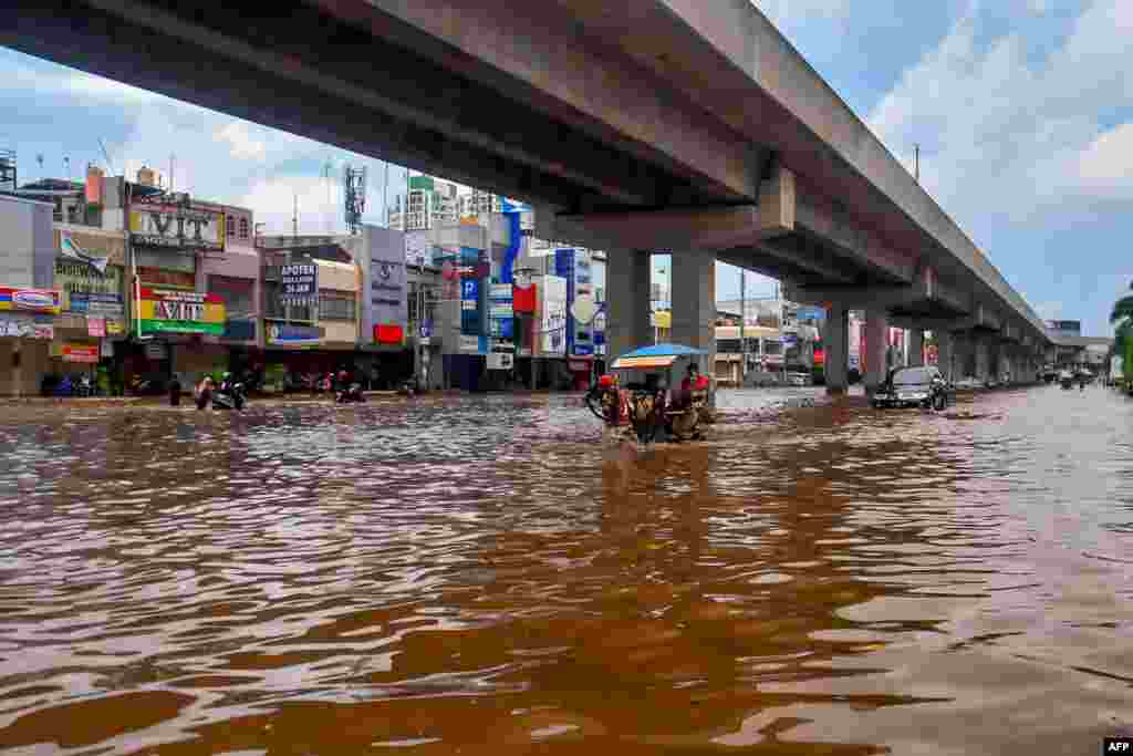 جکارتہ کے شہریوں نے نئے سال کا پہلا دن سیلابی پانی سے درپیش دشواریوں سے نمٹنے میں گزارا۔ زیرِ نظر تصویر میں ایک گھوڑا گاڑی سیلابی پانی سے گزر رہی ہے۔&nbsp; &nbsp;