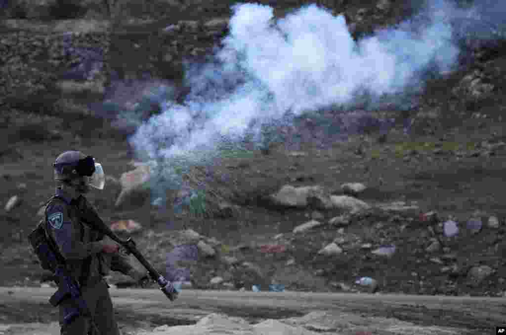 An Israeli border policeman fires a tear gas canister during clashes with Palestinian protesters, outside the Ofer military prison, near the West Bank city of Ramallah.