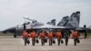 FILE - Indonesian Air Force Sukhoi fighter pilots and crew walk across the tarmac at the Hang Nadim Airport after training for an upcoming military exercise, Oct. 3, 2016.