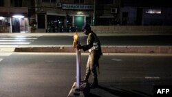Un policier sénégalais installe un point de contrôle avant le couvre-feu à Dakar le 6 janvier 2021.