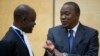 Kenya's President Uhuru Kenyatta (R) speaks to a member of his defense team as he appears before the International Criminal Court at The Hague, Oct. 8, 2014.