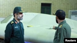  FILE - An undated picture received on Dec 8, 2011, shows a member of Iran's revolutionary guard (R) speaking with revolutionary guard commander Amirali Hajizadeh, at an unspecified location in Iran. 
