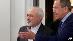 Menteri Luar Negeri Rusia Sergey Lavrov (kanan) menyambut mitranya dari Iran, Mohammad Javad Zarif, di Moskow (17/8). (AP/Ivan Sekretarev)