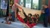 北京旧货市场上的1969年的文革横幅画布，上面有戴红卫兵袖章的毛泽东、其他文革领导人和红卫兵。横幅上写着“大海航行靠舵手” 和“毛主席检阅文化革命大军”（2016年5月16日）