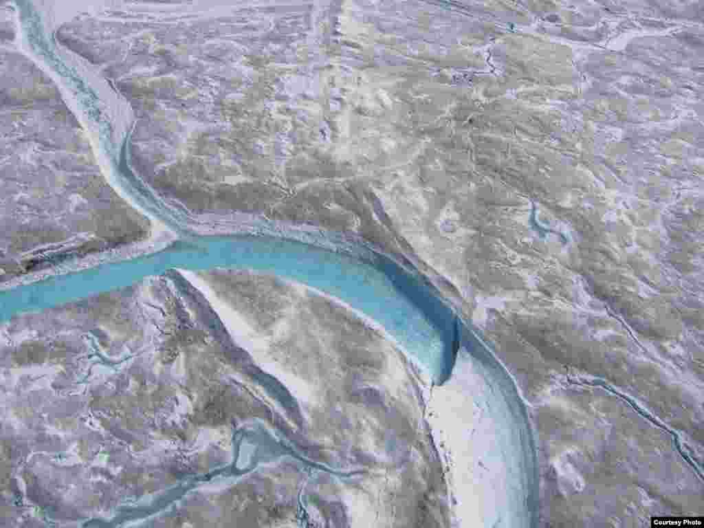 Meltwater formed on the surface of the Greenland ice sheet rushes into supraglacial rivers that then fall into moulins or sinkholes such as the one shown here. (UCLA/Laurence C. Smith)