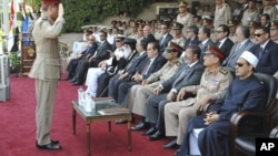 In this image released by the Egyptian President, an Egyptian military officer salutes President Mohammed Morsi, third from right at a graduation ceremony at a military base east of Cairo, Egypt, July 9, 2012.