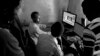 Shakuol, 20, a genocide orphan at his editing studio as he talks to clients while he edits a wedding video, Giporoso, Kigali, Rwanda, Nov 20, 2013. (Hamada Elrasam for VOA)