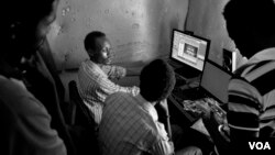 Shakuol, 20, a genocide orphan at his editing studio as he talks to clients while he edits a wedding video, Giporoso, Kigali, Rwanda, Nov 20, 2013. (Hamada Elrasam for VOA)