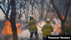 Firemen put out bushfire flames in Red Gully, Western Australia, in this undated handout image. (Evan Collis/Department of Fire and Emergency Services/Handout via Reuters)