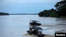 Soldados colombianos patrullan en bote por el río Arauca, en la frontera entre Colombia y Venezuela, visto desde Arauquita, Colombia, el 28 de marzo de 2021.