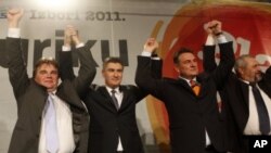 Opposition leader Zoran Milanovic, center left, surrounded by his coalition partners Ivan Jakovic, left, Radomir Cacic, center right and Silvano Hrelja celebrate at their party headquarters in Zagreb, Croatia, December 4, 2011.