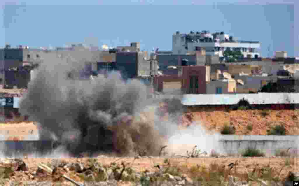 An explosion is seen near Muammar Gadhafi's main compound in the Bab al-Aziziya district in Tripoli, Libya, Tuesday, Aug. 23, 2011. Fresh fighting erupted in Tripoli on Tuesday hours after Moammar Gadhafi's son turned up free to thwart Libyan rebel claims