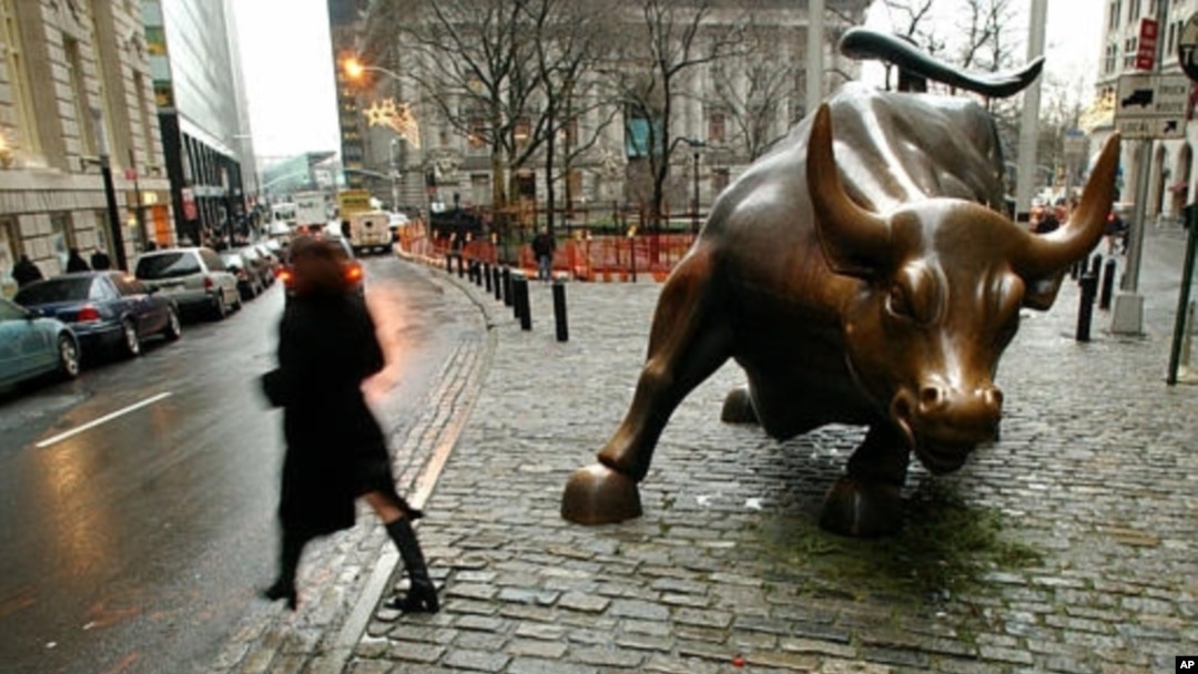 Seorang warga melintasi patung banteng dekat Wall Street di Distrik Finansial kota New York (foto: dok).