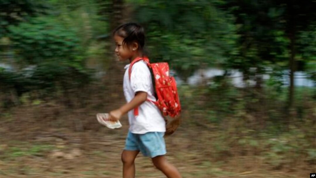 Một học sinh Campuchia trong vùng ngoại ô Phnom Penh chạy vội về nhà sau buổi học, 