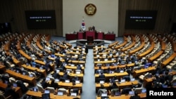 Lawmakers sit inside the hall at the National Assembly, after South Korean President Yoon Suk Yeol declared martial law, in Seoul, South Korea, Dec. 4, 2024.