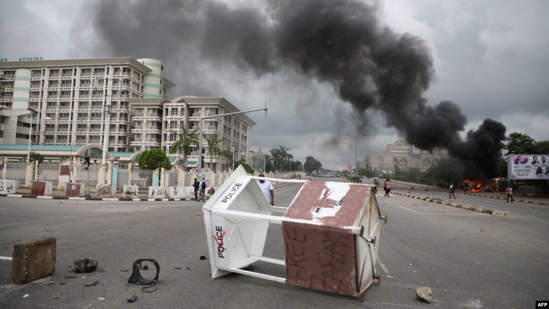 Orang-orang berjalan melintas di sebuah jalan di Abuja saat bentrok antara anggota kelompok Syiah, Gerakan Islam Nigeria (IMN) dan polisi, 22 Juli 2019. (Foto: AFP)
