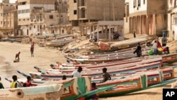 FILE - Children play on fishing boats known as "pirogues" in Dakar, Senegal, June 24, 2023. Large pirogues are used in migrant crossings from Senegal to Spain. 