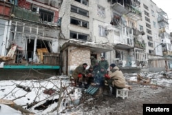 Pripadnici proruskih trupa ispred stambene zgrade koja je oštećena tokom ukrajinsko-ruskog sukoba u Volnovakhi, 11. mart.