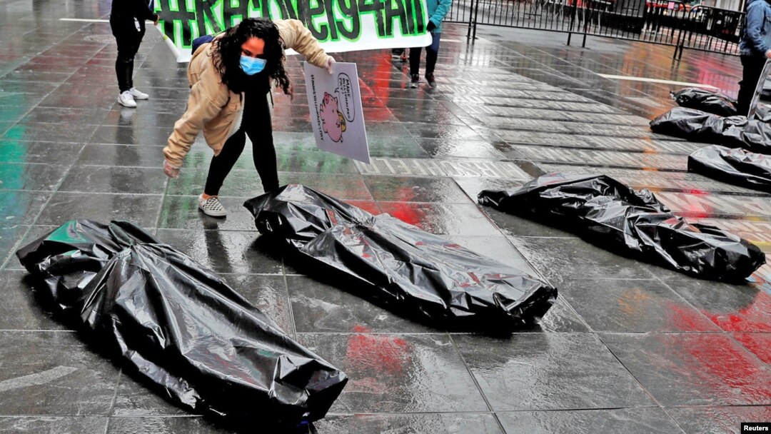 Pengunjuk rasa di Manhattan, New York, beraksi menggunakan kantong jenazah yang mewakili korban tewas corona, 1 Mei 2020. (Foto: Reuters)