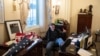 FILE - Richard Barnett, a supporter of President Donald Trump sits inside the office of then-U.S. Speaker of the House Nancy Pelosi during the U.S. Capitol riot, in Washington, Jan. 6, 2021.