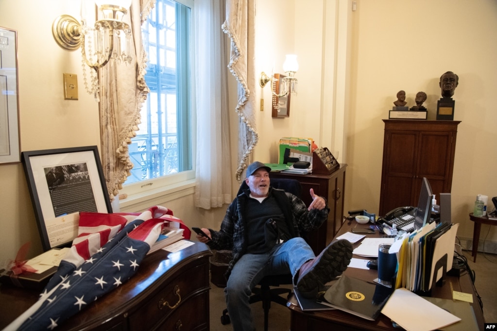 资料照片：特朗普支持者理查德·巴内特闯入众议院议长佩洛西办公室后得意地坐在她的椅子上。(2021年1月6日)(photo:VOA)