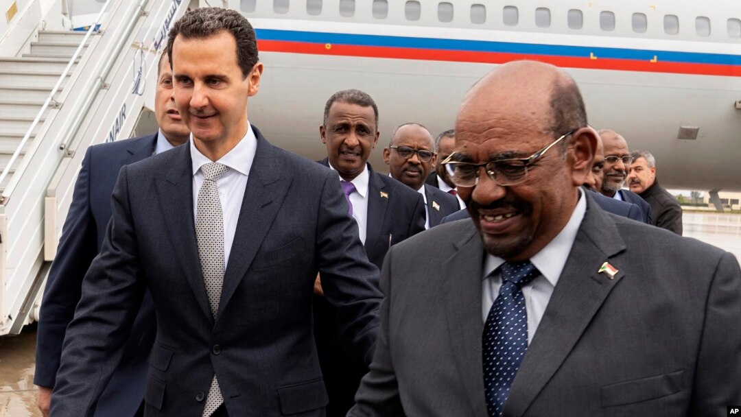 Presiden Suriah Bashar al-Assad (kiri) menerima kunjungan Presiden Omar al-Bashir di Damaskus, Minggu (16/12).