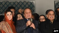 Pakistan's former Prime Minister Nawaz Sharif (C) and leader of the Pakistan Muslim League (PML) party, along with his younger brother and former prime minister Shehbaz Sharif (R) and his daughter Maryam Nawaz (L) speaks with supporters in Lahore on Febru
