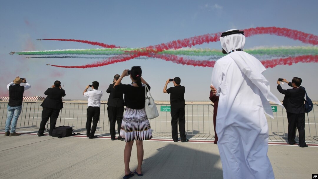 Para turis menyaksikan akrobatik udara pada pameran kedirgantaran Dubai (Dubai Airshow) di Dubai, Uni Emirat Arab, Minggu (8/11).