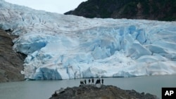 Группа людей любуется видом ледника Менденхолл 8 июня 2023 года в Джуно, Аляска.